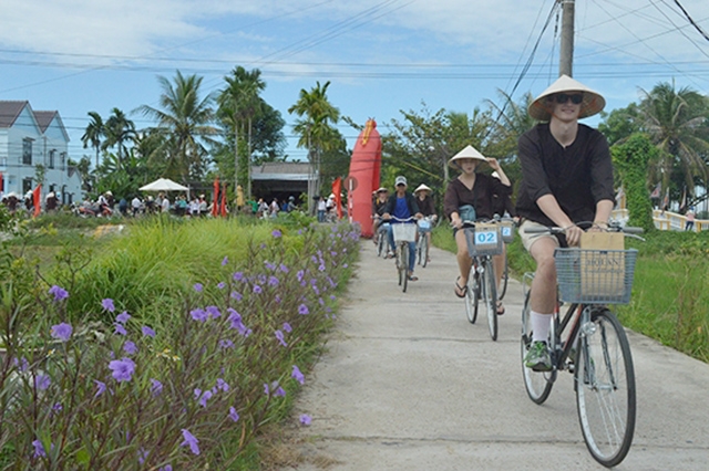 Khách du lịch nước ngoài tham quan làng An Mỹ bằng xe đạp.Ảnh: Hữu Lộc